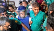 Police personnel escort KM Nurul Huda (C), Bangladesh's former Chief Election Commissioner to a court in Dhaka on June 23, 2025, a day after he was detained on charges of manipulating elections. (Photo by Munir UZ ZAMAN / AFP)
