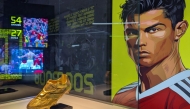 Cristiano Ronaldo's Golden Boot trophy is seen on display beside a portrait of the footballer during the opening of the CR7 LIFE Museum in Hong Kong on July 7, 2025. Photo by Holmes CHAN / AFP
