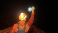 This handout photo taken and released on July 15, 2025 by Indonesia's National Search and Rescue Agency shows a responder using a flashlight during the search for victims of a capsized boat in the waters off Mentawai Islands, West Sumatra. Photo by Handout / Indonesia's National Search and Rescue Agency / AFP