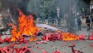Anti-riot police personnel patrol along a street ravaged with burning plastic chairs, allegedly vandalised by the Awami League party activists rebuking a rally by the newly formed Jatiya Nagarik Party, or National Citizen's Party in Gopalganj on July 16, 2025. (Photo by AFP)
