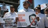Malaysian protesters display placards during a demonstration against the US envoy nominee Nick Adams outside the US embassy in Kuala Lumpur on July 18, 2025. (Photo by Mohd RASFAN / AFP)
