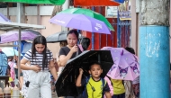  A student holds an umbrella outside a school after classes were suspended due to the tropical storm Wipha in Quezon City, the Philippines, on July 18, 2025. (Xinhua/Rouelle Umali)