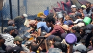 Palestinians gather at a food distribution point in the Nuseirat refugee camp in the central Gaza Strip on July 19, 2025. (Photo by Eyad BABA / AFP)