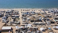 Tents and shelters for Palestinians displaced by conflict are pictured erected at a make-shift camp along the beach near the seaport in the west of Gaza City on July 19, 2025. (Photo by Omar AL-QATTAA / AFP)
