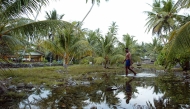 Water welling from the rocky ground forms a new lake in the centre of Amatuku Islet as king tides hit Funafuti Atoll on February 20, 2004. Photo by Torsten BLACKWOOD / AFP