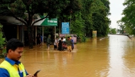 A worker uses his phone on a flooded street in Vietnam's north-central Nghe An province on July 23, 2025, following heavy rains brought by Tropical Storm Wipha. (Photo by AFP)