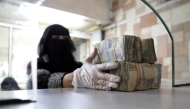 An employee takes bundles of Yemeni riyals / Reuters file photo