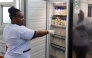 Hannah Wangeci Maina, a senior nurse gestures towards reserves donated breastmilk preserved in a freezer to await screening at a human milk bank in the Pumwani Maternity Hospital, Nairobi on September 04, 2025. (Photo by Tony Karumba / AFP)