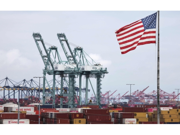 An American flag flies in front of shipping containers and cranes at the Port of Los Angeles on September 26, 2025 in Los Angeles, California. Mario Tama/Getty Images/AFP 