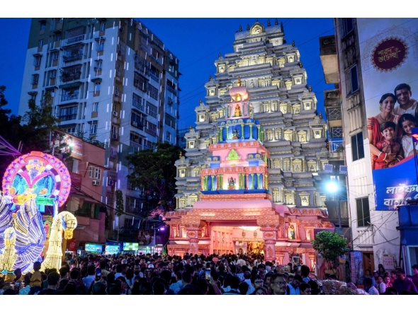 Devotees throng at the entrance during a visit to the 'Pandal' (temporary structure for worship) in Kolkata on September 27, 2025. (Photo by Dibyangshu Sarkar / AFP)