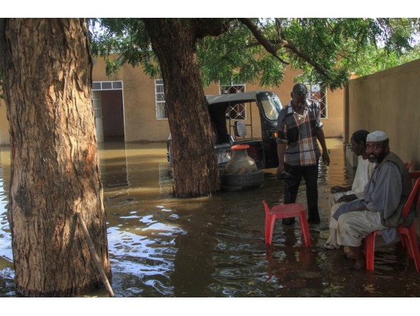 Residents sit in a pool of water due to the flooding of the Nile river in the Sudanese village of Wad Ramli north of Khartoum on October 1, 2025. (Photo by Ebrahim Hamid / AFP)
