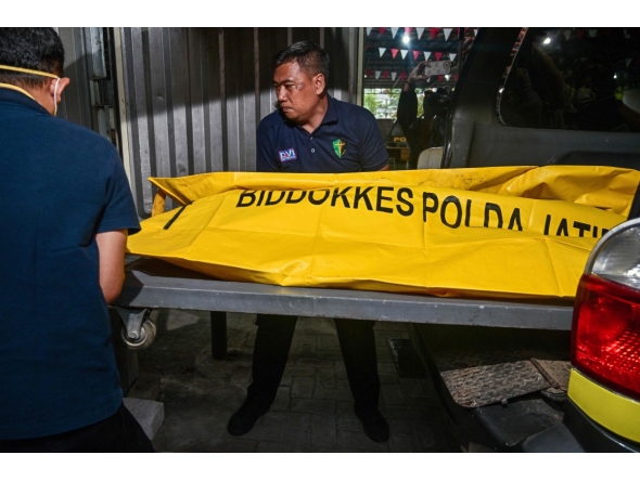 Police officials transfer the remains of a student, killed in a building collapse at the Al Khoziny Islamic boarding school, to a morgue at the Bhayangkara hospital in Surabaya, East Java province on October 4, 2025. (Photo by Juni KRISWANTO / AFP)