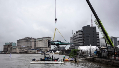 Team Drogba's E1 race boat is lowered into the Lagos Lagoon before racing in Lagos, on October 05, 2025. (Photo by OLYMPIA DE MAISMONT / AFP)