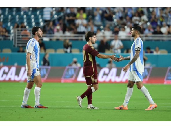 Cristian Romero of Argentina shakes hands with Matias Lacava of Venezuela after the match in Miami Garden. Photo by Leonardo Fernandez/Getty Images/AFP