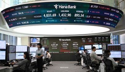 Currency dealers monitor exchange rates in front of a screen showing South Korea's benchmark stock index and the Korean won/USD exchange rate in a foreign exchange dealing room at the Hana Bank headquarters in Seoul on October 27, 2025. (Photo by Jung Yeon-je / AFP)
