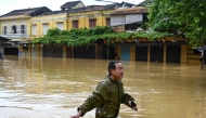 A man wades through a flooded street following heavy rains in Hoi An on October 30, 2025.  Photo by Nhac Nguyen / AFP