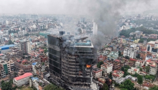 File: Smoke billows from the burning Hilton Hotels, a day after it was set ablaze by protesters in Kathmandu on September 10, 2025. (Photo by Prabin Ranabhat / AFP)

