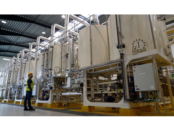 A worker looks at a row of machinery in Everfuel's new HySynergy electrolysis plant in Fredericia, Denmark, on November 3, 2025. Photo by James BROOKS / AFP