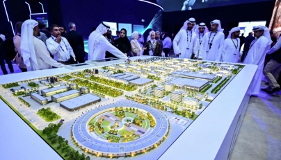Guests look at a model of the largest data center in the UAE under construction in Abu Dhabi as the Stargate initiative, a joint venture between G42, Microsoft, and OpenAI, during the Abu Dhabi International Petroleum Exhibition & Conference (ADIPEC) in Abu Dhabi on November 3, 2025. (Photo by Giuseppe Cacace / AFP)
