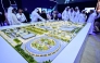 Guests look at a model of the largest data center in the UAE under construction in Abu Dhabi as the Stargate initiative, a joint venture between G42, Microsoft, and OpenAI, during the Abu Dhabi International Petroleum Exhibition & Conference (ADIPEC) in Abu Dhabi on November 3, 2025. (Photo by Giuseppe Cacace / AFP)
