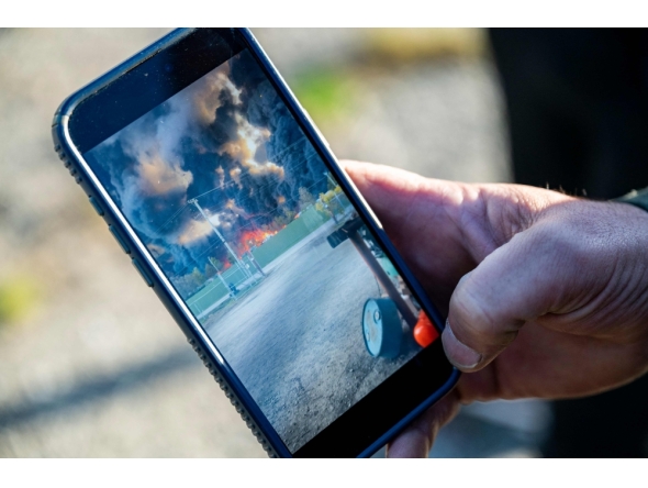 An employee of Kentucky Truck Parts and Services shows a phone video that was taken after a UPS MD-11 cargo plane crashed on November 5, 2025. Michael Swensen/Getty Images/AFP 