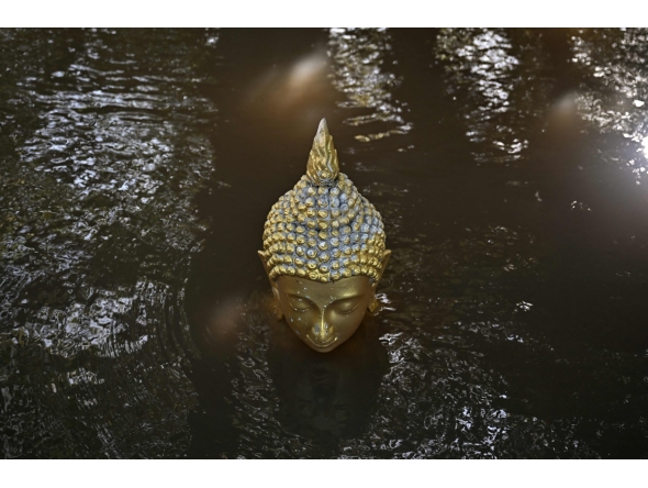 Floodwaters cover a Buddhastatue of at Wat Taku Buddhist temple in Bang Ban district in the central Thai province of Ayutthaya on November 14, 2025. (Photo by Lillian SUWANRUMPHA / AFP)