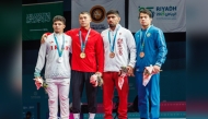 Qatar's Shaheen Mohammad (third left) with the podium winners of the men's 77kg wrestling event.