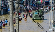Damaged wires dangle from electric poles as an army truck wades through a flooded street after heavy rainfall in Wellampitiya on the outskirts of Colombo on November 30, 2025. (Photo by Ishara S. Kodikara / AFP)