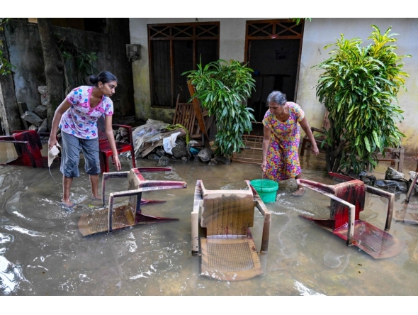 Residents salvage their belongings at an inundated house following flash floods in the aftermath of Cyclone Ditwah, in Wellampitiya on the outskirts of Colombo on December 3, 2025. (Photo by Ishara S. Kodikara / AFP)
