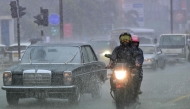 Commuters drive through a flooded street amid heavy rains in Colombo on December 5, 2025. (Photo by Ishara S. KODIKARA / AFP)
