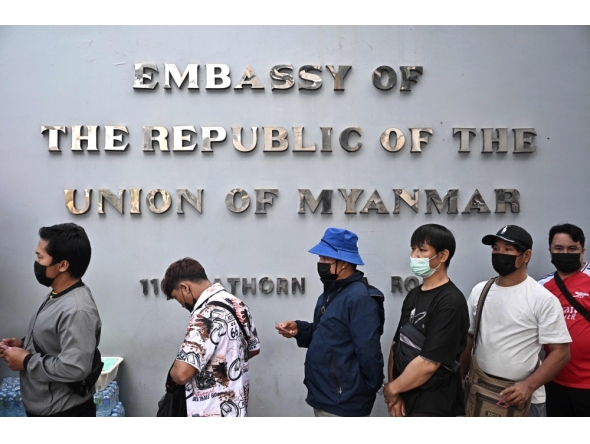 Myanmar nationals living in Thailand queue up outside the Myanmar Embassy for early voting ahead of the Myanmar general election, in Bangkok on December 6, 2025. (Photo by Lillian Suwanrumpha / AFP)
 