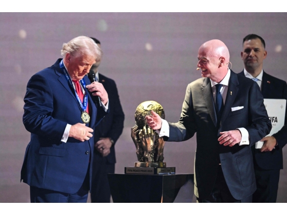 US President Donald Trump reacts as he receives the FIFA Peace Prize from Italian Fifa President Gianni Infantino at the Kennedy Center, in Washington, DC, on December 5, 2025. (Photo by Saul Loeb / AFP)
 