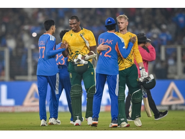 South Africa's Lungi Ngidi (2L) and Corbin Bosch (2R) congratulate India's Shubman Gill and Tilak Varma for their team's win at the end of the fifth Twenty20 international cricket match between India and South Africa at the Narendra Modi Stadium in Ahmedabad on December 19, 2025. (Photo by Shammi Mehra / AFP) 