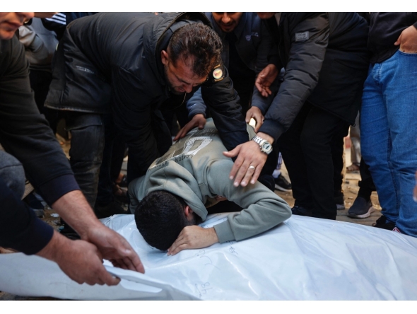 A relative mourns over the bodies of members of the Al-Nader family, who were reportedly killed the previous day in an Israeli shelling on a school-turned-shelter in the Tuffah neighbourhood of Gaza City, ahead of their funeral on December 20, 2025. (Photo by Omar AL-QATTAA / AFP)
