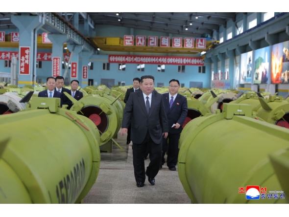 This undated picture released by North Korea's official Korean Central News Agency (KCNA) on December 26, 2025 shows North Korean leader Kim Jong Un (C) visiting major munitions industry enterprises to acquaint himself with the missile and shell production at an undisclosed place in North Korea. (Photo by KCNA VIA KNS / AFP) 