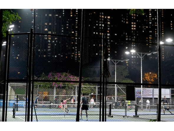 This picture taken on December 23, 2025 shows people playing pickleball in the playground of a residential area in Hanoi. (Photo by Nhac Nguyen / AFP) 