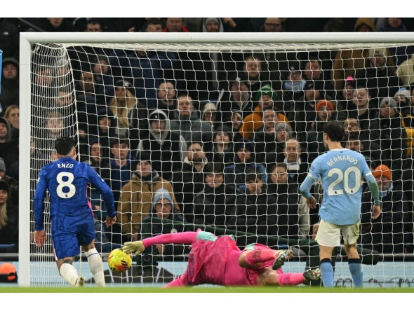 Manchester City's Italian goalkeeper #25 Gianluigi Donnarumma makes a save as Chelsea's Argentinian midfielder #08 Enzo Fernandez prepares to score during the English Premier League football match between Manchester City and Chelsea at the Etihad Stadium in Manchester, north west England, on January 4, 2026. (Photo by Oli SCARFF / AFP)
