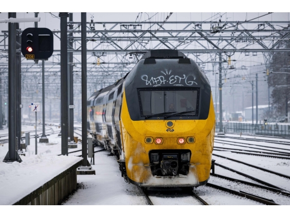 A train moves along a platform covered in snow, at Arnhem Central Station, as train service is resuming after an IT outage at the Dutch national railway service Nederlandse Spoorwegen (NS), on January 6, 2026. (Photo by Robin van Lonkhuijsen / ANP / AFP)