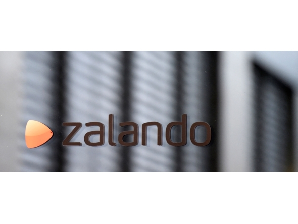 The logo of German shoes and clothing retailer Zalando is pictured at the office door in Berlin September 30, 2014. German online fashion retailer Zalando said on January 8, 2026 that it would close a distribution centre in the eastern city of Erfurt and lay off 2,700 employees to restructure its European logistics network. (Photo by Tobias Schwarz / AFP)