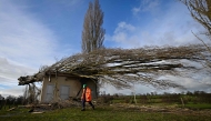 A worker secures the area around a fallen tree on a water borehole, following the passage of the storm Goretti, in Saint-Gabriel-Brecy, near Martragny, northwestern France. (Photo by Lou Benoist / AFP)