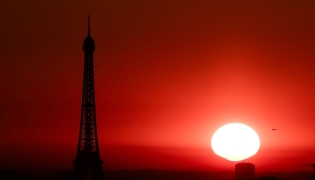 (Files) The sun rises by the Eiffel Tower in Paris on July 1, 2025. (Photo by Thibaud Moritz / AFP)
 