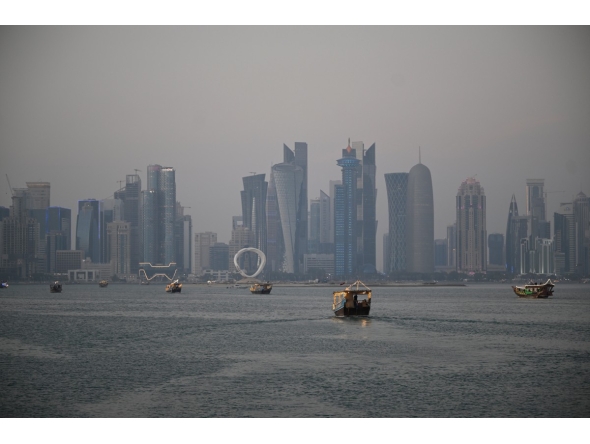 Tourists ride traditional boats along the corniche promenade in Doha on January 13, 2026. (Photo by Mahmud HAMS / AFP)
