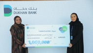A Dukhan Bank official presenting the grand prize to the winner.