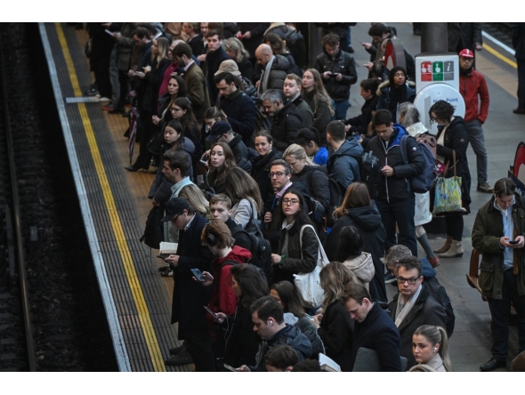 Commuters wait for a train on the platform at Earls Court Tube station in London on January 15, 2026. Photo by JUSTIN TALLIS / AFP