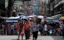 Pedestrians walk as they shop at a market in Manila on January 26, 2022. (Photo by JAM STA ROSA / AFP)