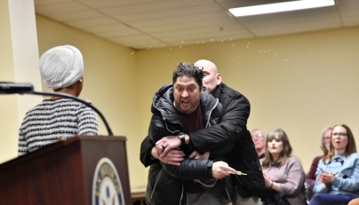 A man is tackled after spraying an unknown substance at US Representative Ilhan Omar (D-MN) (L) during a town hall she was hosting in Minneapolis, Minnesota, on January 27, 2026. (Photo by Octavio Jones / AFP)