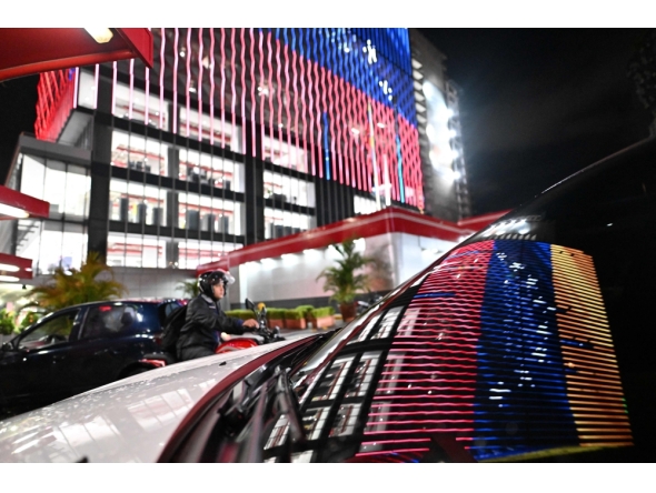 A Venezuelan flag is reflected in the windscreen of a car in Caracas on January 30, 2026. (Photo by Juan Barreto / AFP)