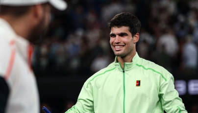 Spain's Carlos Alcaraz signs a television camera after beating Germany's Alexander Zverev in Melbourne on January 30, 2026. (Photo by Izhar Khan / AFP) 