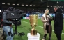 Media representatives are seen by the German Cup trophy displayed prior to the start of the German Cup (DFB-Pokal) quartefinal football match between Holstein Kiel and VfB Stuttgart in Kiel, northern Germany on February 4, 2026. (Photo by Ibrahim OT / AFP) 
