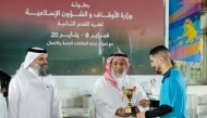 Minister of Awqaf and Islamic Affairs H E Ghanem bin Shaheen bin Ghanem Al Ghanem honouring a winner at the event.